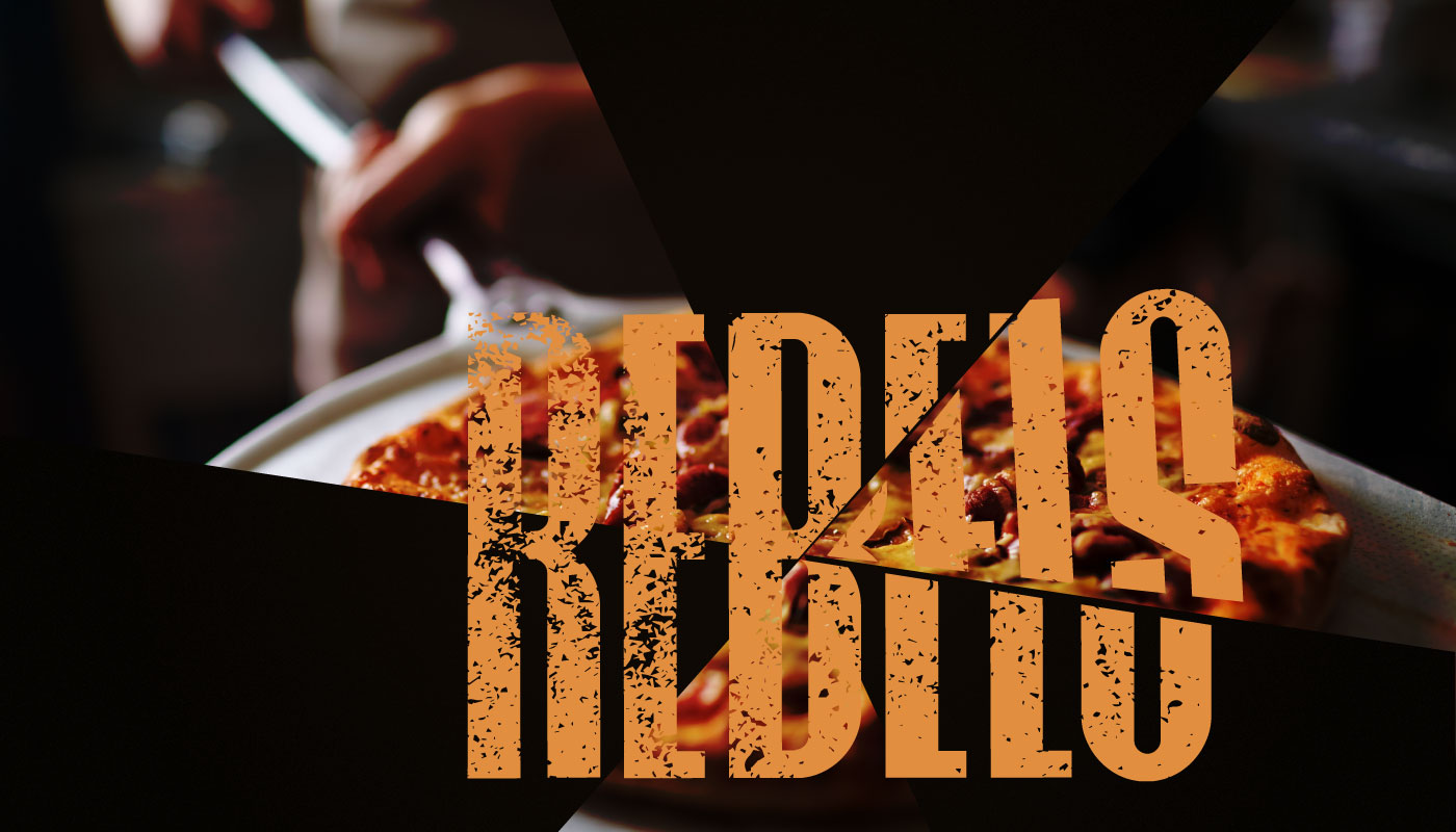 Large, distressed orange cut-wordmark logo for Rebels Pizza, overlaid on a dark background with a triangular cutout revealing a fresh pizza.